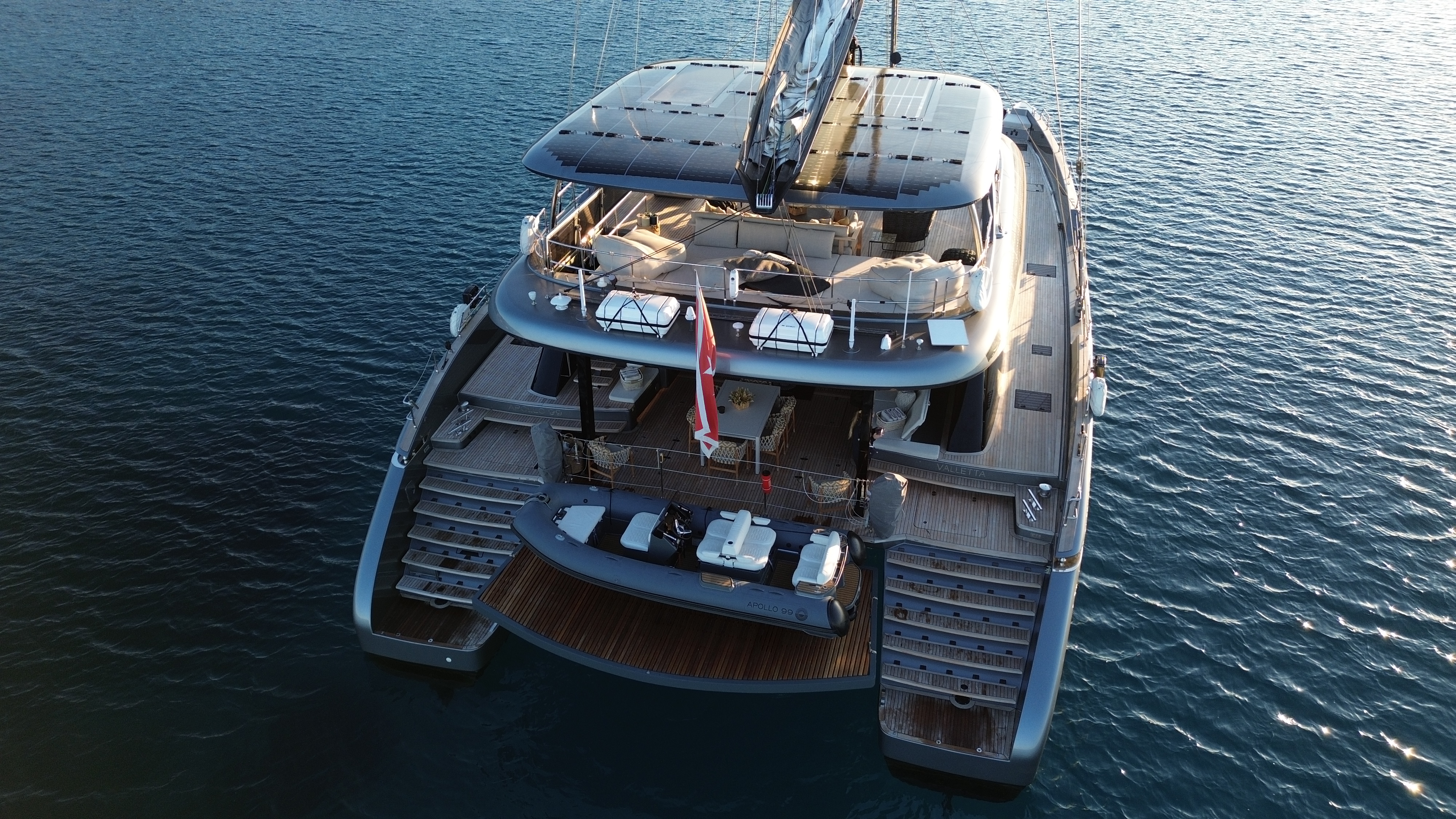 Aerial view of luxury yacht with solar panels and seating area.